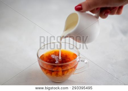 Pouring Milk From The Jug Into A Cup Of Black Tea