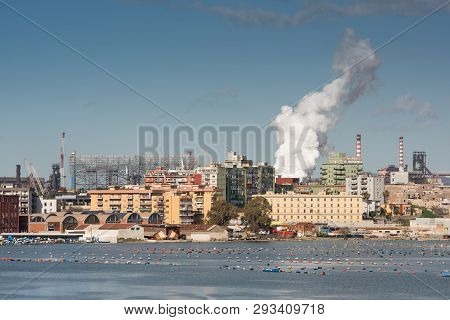 The Front-end Of A Steel Plant, With A Bulk Carrier With Iron Ore Being Unloaded
