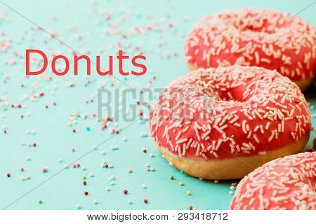 Donuts Decorated With Icing On Blue Background.