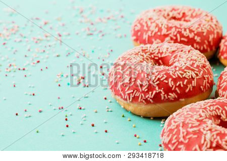 Donuts Decorated With Icing On Blue Background.