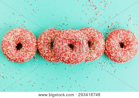 Donuts Decorated With Icing On Blue Background.