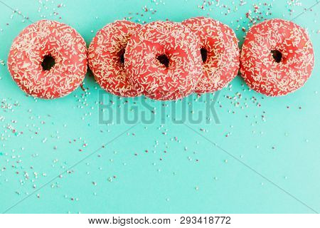 Donuts Decorated With Icing On Blue Background.