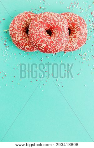 Donuts Decorated With Icing On Blue Background.