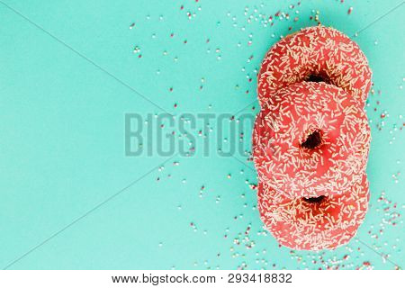 Donuts Decorated With Icing On Blue Background.
