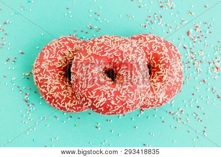 Donuts Decorated With Icing On Blue Background.