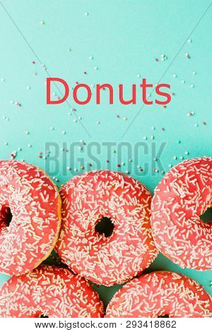 Donuts Decorated With Icing On Blue Background.