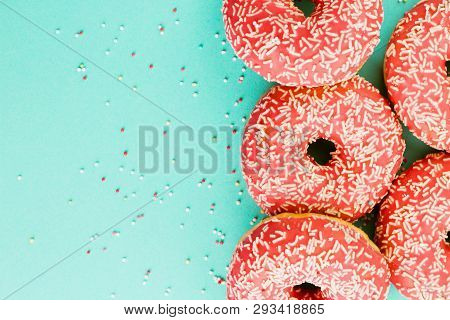 Donuts Decorated With Icing On Blue Background.