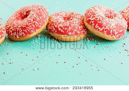 Donuts Decorated With Icing On Blue Background.