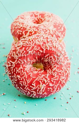 Donuts Decorated With Icing On Blue Background.