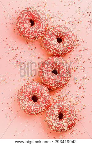 Five Coral Donuts Lying In A Line.