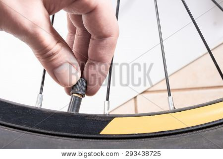 Hand Unscrews A Wheel Valve Bike Pump
