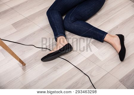 An Elevated View Of Woman Stumbling With An Electrical Cord