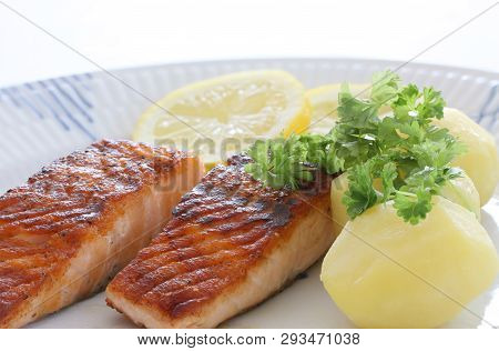 Grilled Salmon Fish Filets On A Plate With Potatoes, Parley And Slices Of Lemon. Close Up Stock Phot