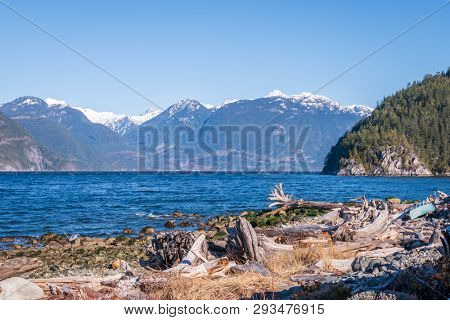 Fantastic view over ocean, snow mountain and rocks at Sechelt inlet in Vancouver, Canada.