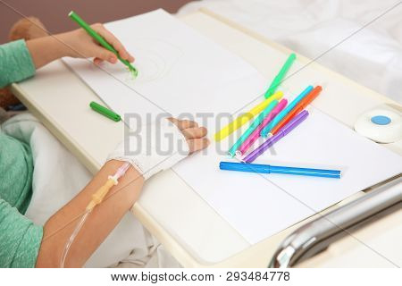 Little Child With Infusion Drip Drawing In Hospital Bed, Closeup