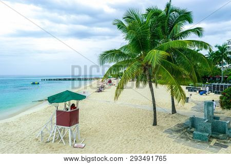 Tropical Caribbean Island Beach Scene. Life Guard Tower, Coconut Palm Trees, White Sand.