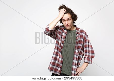 Portrait Of Preoccupied Upset Young Man In Casual Clothes Looking Down Putting Hand On Head Isolated