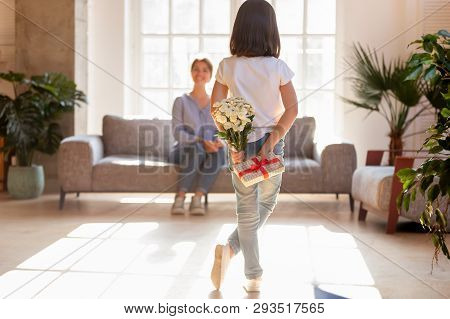 Rear View Daughter Hide Behind Back Surprise For Mum