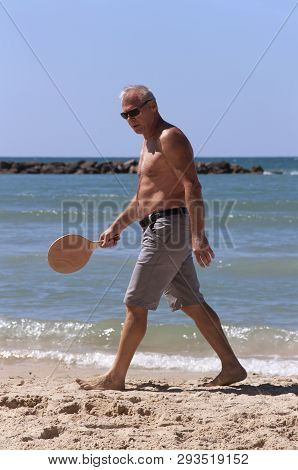Handsome Grown Man Playing Tennis On The Beach
