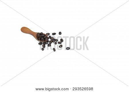 In Selective Focus Many Dark Roasted Coffee Beans On A Wooden Spoon And On The Floor, White Isolated