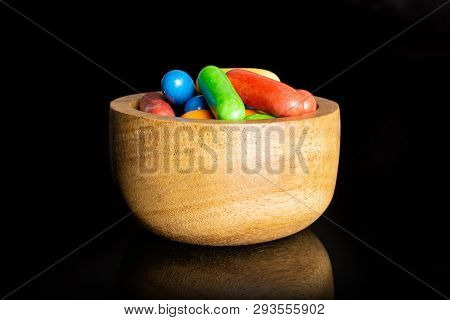 Lot Of Whole Sweet Licorice Comfit In A Wooden Bowl Isolated On Black Glass