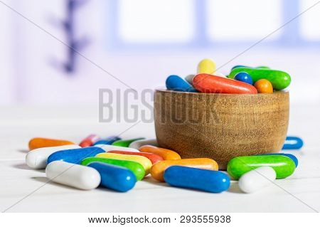 Lot Of Whole Sweet Licorice Comfit In A Wooden Bowl With Blue Window In Background