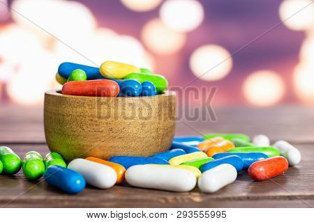 Lot Of Whole Sweet Licorice Comfit In A Wooden Bowl With Lights In Dark Background
