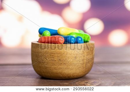 Lot Of Whole Sweet Licorice Comfit Closeup In A Wooden Bowl With Lights In Dark Background