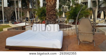 A Comfortable Bed For Tan And Rest With White Matress Near A Rocking Chair Stay Empty In The Hotel G