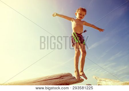 Toned Photo Of Happy Child Jumping On The Summer Beach
