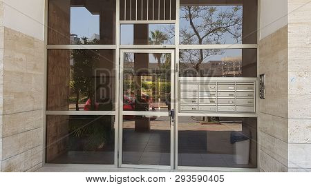 Closed Transparent Glass Door And Mail Boxes At The Entrance To Shared Building In The City