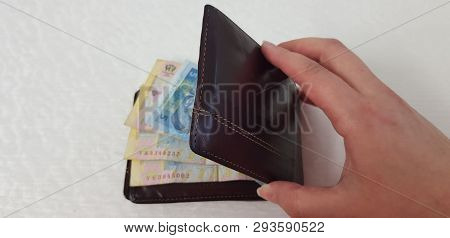 Brown Leather Wallet Full Of Various Hryvnia Banknotes With Female Hand Isolated On White Background