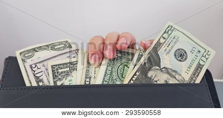 Female Fingers On A Group Of American Dollar Bills In A Pocket Of Black Leather Folder