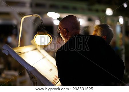 Paros, Greece, 15 September 2018 Night Portrait Of A Tourist Looking With Interest At A Restaurant M