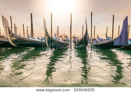 Gondolas Lay Dormant Waiting For Tourists, At Sunset With Long Shadows, And The Church Of Santa Mari