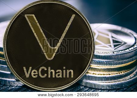 Coin Cryptocurrency Vechain On The Background Of A Stack Of Coins. Vet Coin.