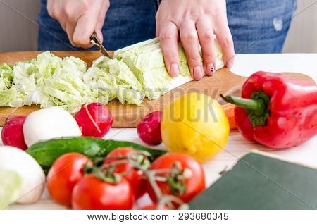 Woman Hands Cutting Vegetables On Wooden Background