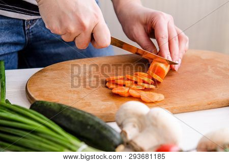Woman Hands Cutting Vegetables On Wooden Background