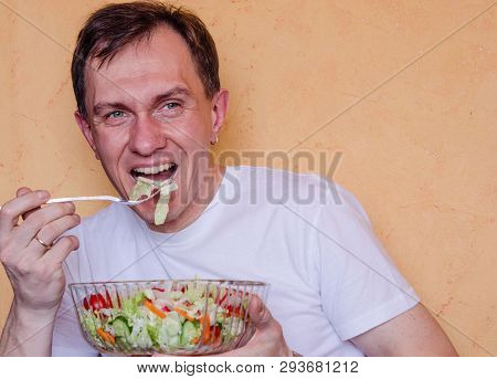 Young Man Takes Ready Vegan Salad