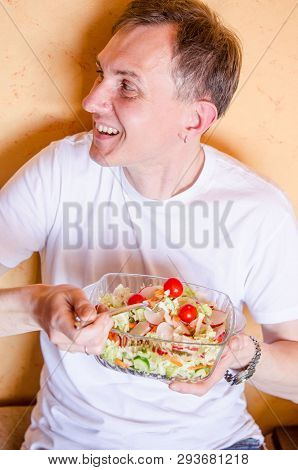 Young Man Takes Ready Vegan Salad