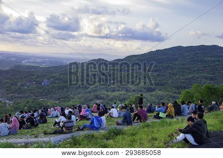 Yogyakarta, Indonesia - April 2, 2019 People Sitting On The Ground And Watch For Sun Set On Paraglid
