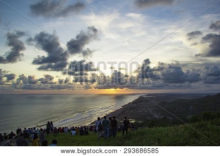 Yogyakarta, Indonesia - April 2, 2019 People Sitting On The Ground And Watch For Sun Set Paragliding