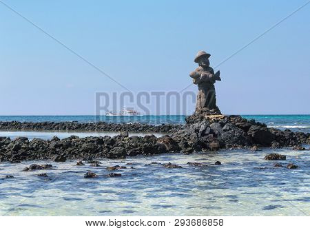Jeju Island, South Korea, September 10, 2015: Statue Of Fisherman Made Of Lava Rock In The Sea