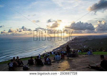 Yogyakarta, Indonesia - April 2, 2019 People Sitting On The Ground And Watch For Sun Set Paragliding