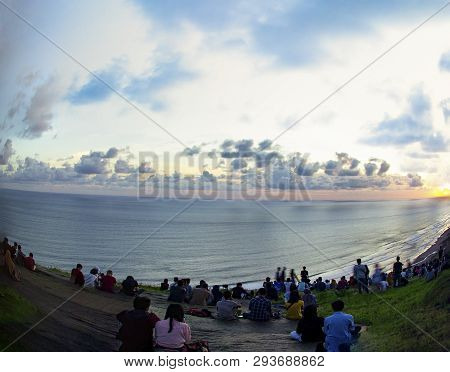 Yogyakarta, Indonesia - April 2, 2019 People Sitting On The Ground And Watch For Sun Set Paragliding