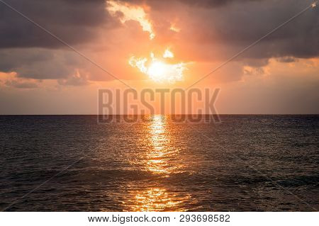 Sunrise Through The Rain Clouds Of New Smyrna Beach, Florida Usa. Waves Beat The Sea Foam On The San