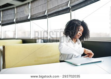 Сheerful Business African American Lady With Afro Hair, Wear White Blouse Sitting At Table And Work