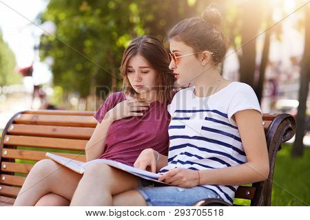Cheerful Funloving Girls Look Through Final Issue Of Local Magazine, Discuss New Events And People. 