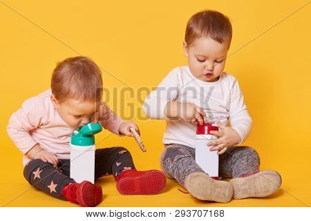 Cute Twin Sisters Have A Meal Together Without Parents, Play With Each Other, Spend Free Time. One O