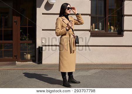 Young Pleasant Blackhaired Woman Looks In Distance, Tries To Choose Better Road To Have Long Walk. F